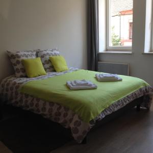 a bed in a room with two towels on it at Le Châtaignier in Forbach