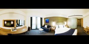 ein Hotelzimmer mit einem großen Bett und einem Schreibtisch in der Unterkunft Holiday Inn Express Shanghai Jinsha by IHG in Shanghai
