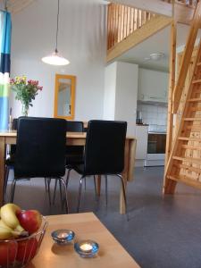um quarto com uma mesa com cadeiras e uma taça de fruta em Ystad Camping em Ystad