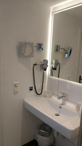 a bathroom with a sink and a mirror and a phone at Hotel Neuwirt in Ramsau am Dachstein