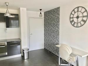 a kitchen with a large clock on the wall at LeT2 Appartement Moderne avec Terrasse et Parking in Strasbourg