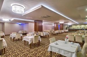 a restaurant with white tables and chairs and a room at Tugcu Hotel Select in Bursa