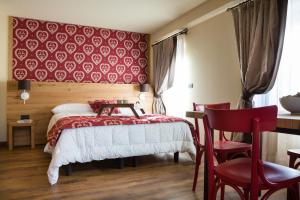 a bedroom with a bed and a red wall at Maison Fosson in Champoluc