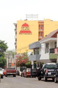 eine belebte Stadtstraße mit einem Hotel-Verleih-Schild an einem Gebäude in der Unterkunft Hotel Plaza Independencia in Villahermosa