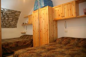1 dormitorio con 2 camas y armarios de madera en Appartamenti Serena - La Grotta, en Gargnano
