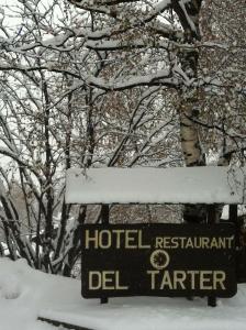 a sign on a pole in front of a forest at Hotel del Tarter in El Tarter