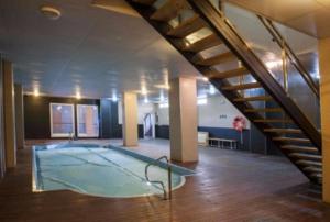 einen großen Pool in einem Zimmer mit einer Treppe in der Unterkunft Miramar Ski a pie de pista - Apartamento Deluxe, 4 habitaciones in Sierra Nevada