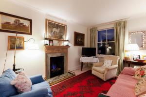 ロンドンにあるAttractive Chelsea apartment sleeps 4のリビングルーム(青いソファ、暖炉付)
