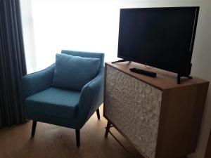 a living room with a chair and a television on a dresser at Ansiturismo Alojamento in Ansião