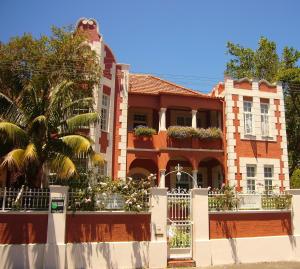 dom z białym płotem przed nim w obiekcie The Villa Rosa Guest House & Self-catering Apartments w Kapsztadzie