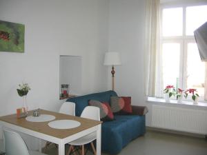 een woonkamer met een blauwe bank en een tafel bij Studio Aleja 77 in Częstochowa