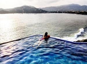 a woman laying on a raft in the water at Espuma Hotel - Adults Only in Zihuatanejo