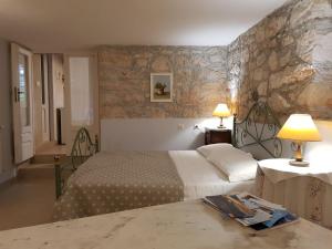 a bedroom with two beds and a stone wall at Apartments Gabri in Mali Lošinj