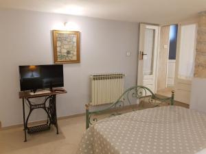 a bedroom with a bed and a tv and a table at Apartments Gabri in Mali Lošinj