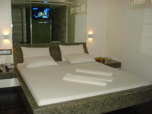 a bed with white pillows and towels on it at Hotel Colonial (Adult Only) in Olinda