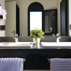 uma casa de banho com 2 lavatórios e um espelho grande em Uma Suites Parada del Marqués em Sevilha