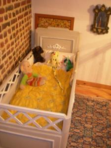 a crib with stuffed animals sitting in it at La Fermette de la Vache Rousse in Rosult