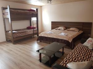 una camera con due letti a castello e un divano di Guest House Khergiani a Mestia