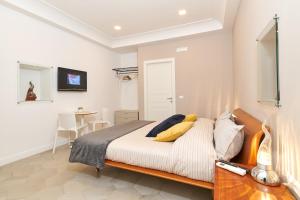 Un dormitorio con una cama con almohadas amarillas. en A Casa del Principe LT en Nápoles