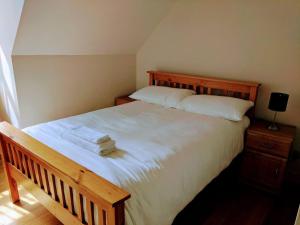 a bedroom with a large white bed with a wooden headboard at 17 Crusader House in Bristol