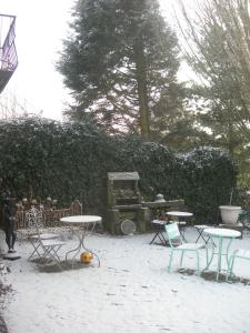 une terrasse avec des tables et des chaises dans la neige dans l'établissement La Fermette de la Vache Rousse, à Rosult