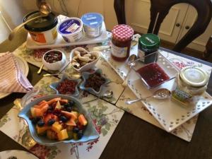 a table topped with food and a bowl of fruit at Vine Cottage in Farnham