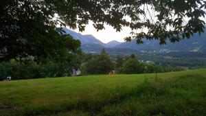 un campo de césped verde con montañas en el fondo en Les Rochers en Saint-Savin