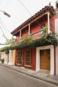 a red building with a balcony on a street at Casa El Carretero Hotel Boutique in Cartagena de Indias