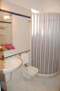 a bathroom with a white toilet and a sink at Hotel Conti in Vulcano