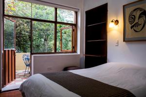 una camera da letto con un letto e una grande finestra di Hostal Posada del Maple a Quito