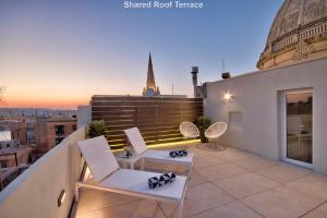 balkon z krzesłami i widokiem na miasto w obiekcie Mint Suite No3 w mieście Valletta