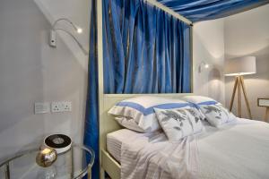 sypialnia z łóżkiem z niebieską zasłoną w obiekcie Mint Suite No3 w mieście Valletta
