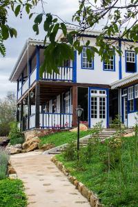 Casa azul y blanca con porche en Pousada Chão de Minas Ouro Preto, en Ouro Preto