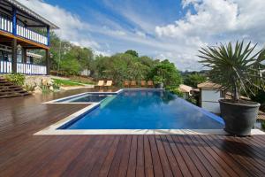 a swimming pool on a wooden deck with a house at Pousada Chão de Minas Ouro Preto in Ouro Preto