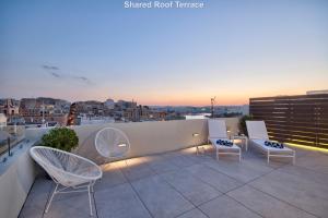 een dakterras met stoelen en uitzicht op de stad bij Mint Suite No2 in Valletta