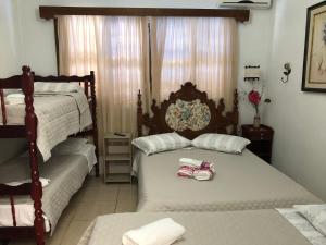 1 dormitorio con 2 camas y toallas. en Pousada Olena, en São Gabriel
