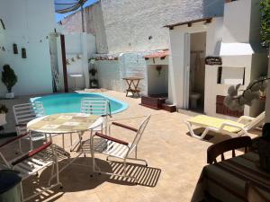 a patio with a table and chairs and a swimming pool at Pousada Olena in São Gabriel