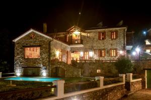 a large stone house with a swimming pool at night at Eos - Authentic Experience in Skíti
