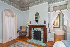 a living room with a fireplace and a mirror at Lumber Baron Inn and Gardens in Denver