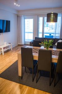 Una sala de estar con una mesa y sillas y un sofá. en Antintorni Apartment 7, en Pori