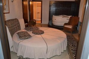 ein Schlafzimmer mit einem Bett mit Leopardenkissen und einer Badewanne in der Unterkunft Oasi in Kato Loutraki