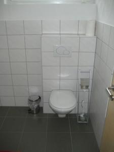 ヴィリンゲンにあるStrycker Ferienappartementの白いタイル張りの客室で、バスルーム(トイレ付)が備わります。