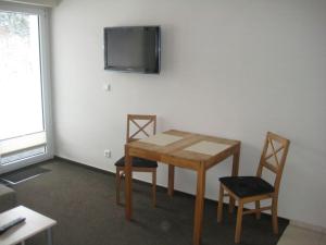 ヴィリンゲンにあるStrycker Ferienappartementのテーブル、椅子2脚、テレビが備わる客室です。