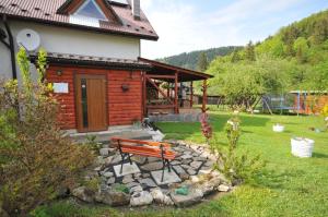 a bench sitting in front of a cabin at Ubytovanie Sokolica in Červený Kláštor