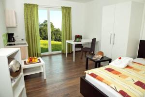 a hotel room with a bed and a kitchen with a table at Erlachmühle in Mondsee