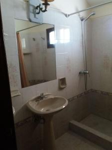 y baño con lavabo y ducha con espejo. en Villa Cristina, en Punta del Este
