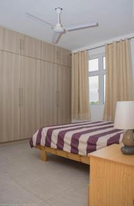 a bedroom with a bed and a large window at Villa Alexis - Location de vacances à Trou aux Biches in Trou aux Biches