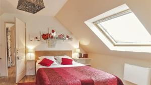 a bedroom with a large bed with a red blanket at Location de La Ferme De Kerraoul in Combrit +10 photos