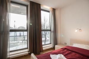 a bedroom with a red bed and a large window at Riga City Center Apartment in Riga