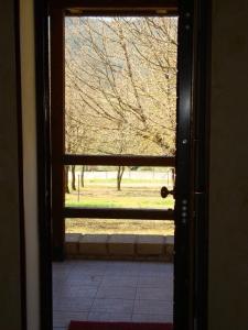 una porta aperta con vista su un parco attraverso una finestra di Agriturismo Centuria a San Pio delle Camere